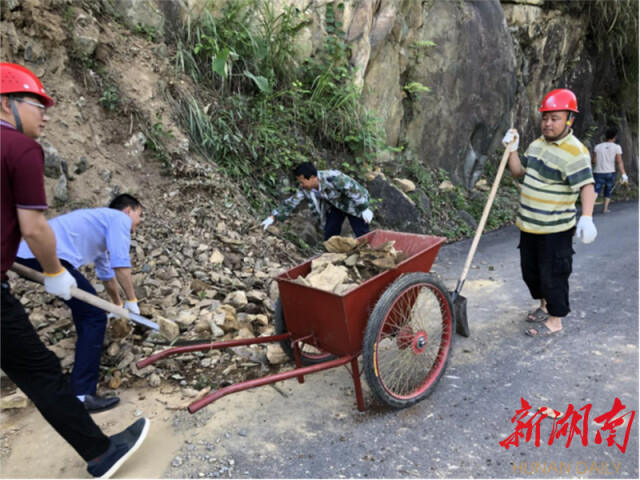 环境组组长石良平和组员一起义务清扫入村路