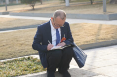 在现场｜会议开幕前，这名省政协委员为何在花坛边席地而坐？