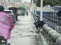 潇湘晨报丨桥头积水十厘米，怀化一城管队员徒手疏通桥头排水口被网友抓拍，他说“这是本职工作”