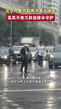 北京一男孩冒雨为老人递伞，见其不便又折返撑伞守护