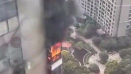 长沙一小区高层着火 邻居楼顶架水带支援灭火