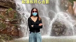女子瀑布前留影 没想到身后出现一位大哥全程“抢镜”