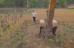 师傅见老人锄地费力，调转挖掘机帮忙松土