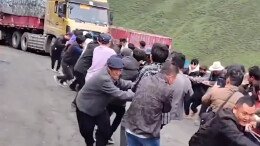 大货车打滑被困 近百名村民和游客齐心拉车救援