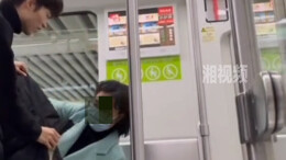 阿姨横躺地铁座椅上玩手机 男生利用盖衣服“暖心”地让她坐起