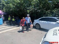 老人回家误入高速收费站，交警打着扇子送老人回家