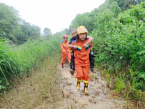 暴雨中，消防员背出被泥石困住的老人