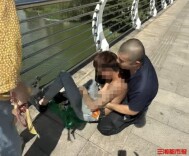 小伙刚刚跨过桥边栏杆，路过的蓝天救援队队员一把抱住他