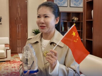 湖南农人董敏芳领奖归来，行李箱里最珍视的是一面国旗