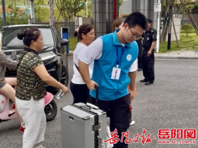 岳阳学院迎新日，这家三口不忙着办手续，却先穿上红马甲