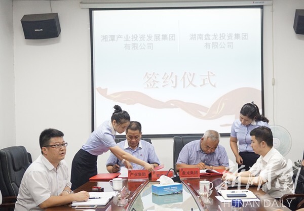 彭连阳,冯友根分别代表湘潭产业集团和盘龙投资集团签约.