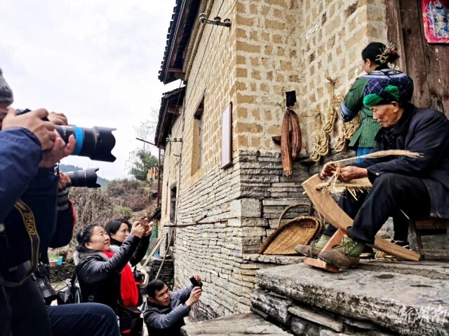 苗家阿公赶着牛在翻耕农田,阿婆在熟练地编织草鞋;银饰坊内打制银器