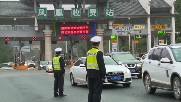 凤凰高速收费站车辆络绎不绝凤凰交警正在有序疏导交通上车检查并进行