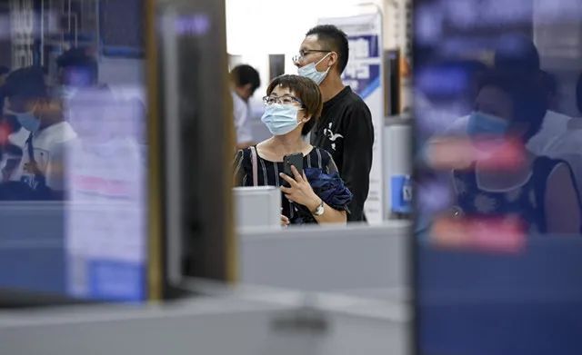 ▲ 7月24日，求职者在招聘会现场查看招聘信息。来源：新华社。