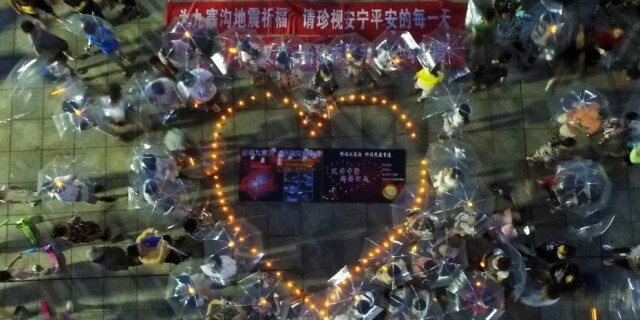 长沙市民点烛撑伞为地震灾区祈福