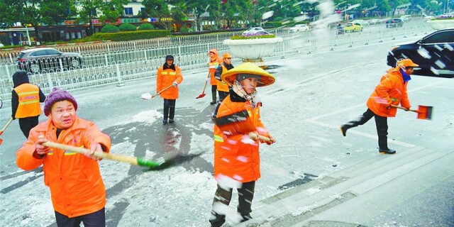 环卫工人铲冰除雪保路畅